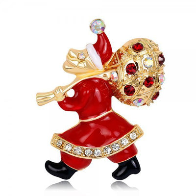 Decorative brooch of a Santa Claus figure with red suit, gold hat, and crystal accents on a white background.