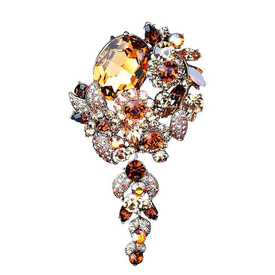 Jewelry brooch with orange and clear gemstones on a white background