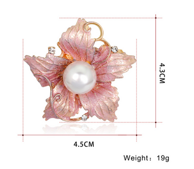 Pink floral brooch with a pearl center and measurements on a white background