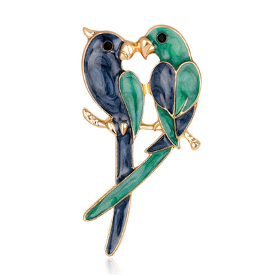 Brooch with two birds in a kissing pose on a white background
