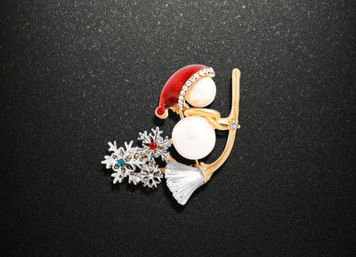 Decorative brooch with Santa hat, pearl, and snowflake design on a black background
