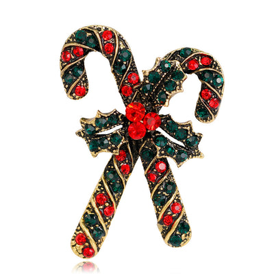 Decorative candy cane brooch with red and green gemstones on a white background