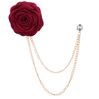 Red rose-shaped brooch with gold chain on a white background