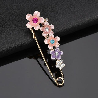 Decorative brooch with floral design and gemstones on a black background