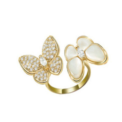 Gold butterfly-shaped rings with gemstones on a white background