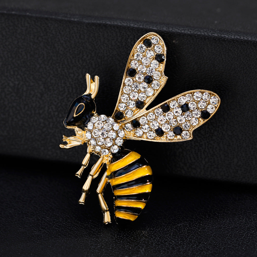 Bee-shaped brooch with gold, black, and yellow colors on a dark background