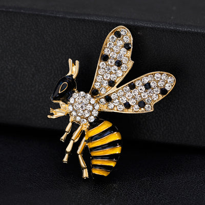 Bee-shaped brooch with gold, black, and yellow colors on a dark background
