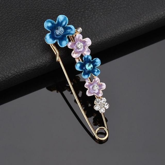 Decorative brooch with blue and purple flowers on a dark background