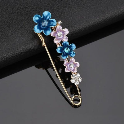 Decorative brooch with blue and purple flowers on a dark background