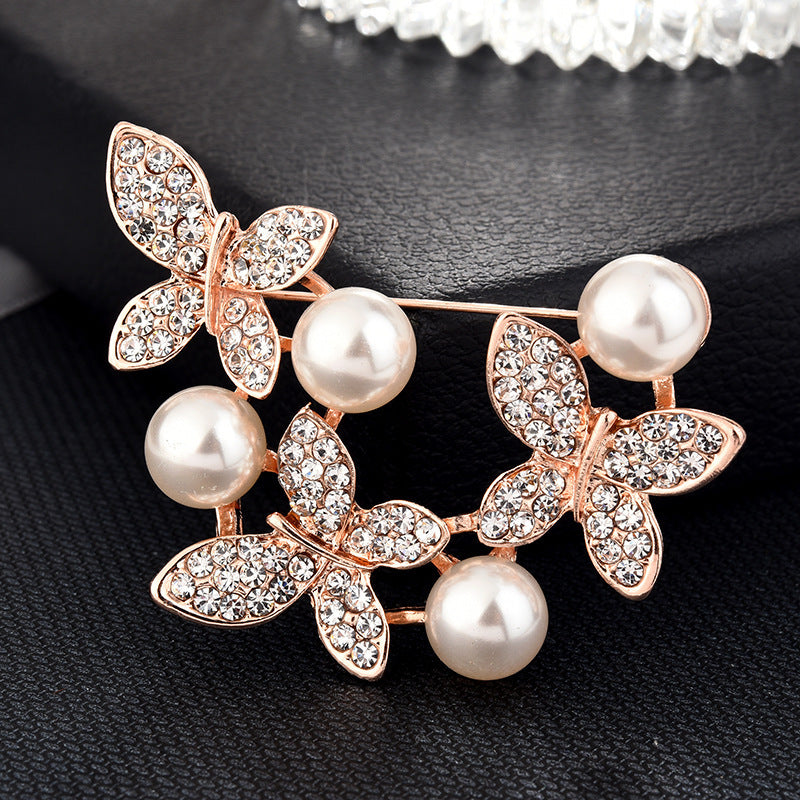 Brooch with butterfly design and pearls on a black background