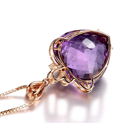 Purple gemstone necklace with gold chain on a white background