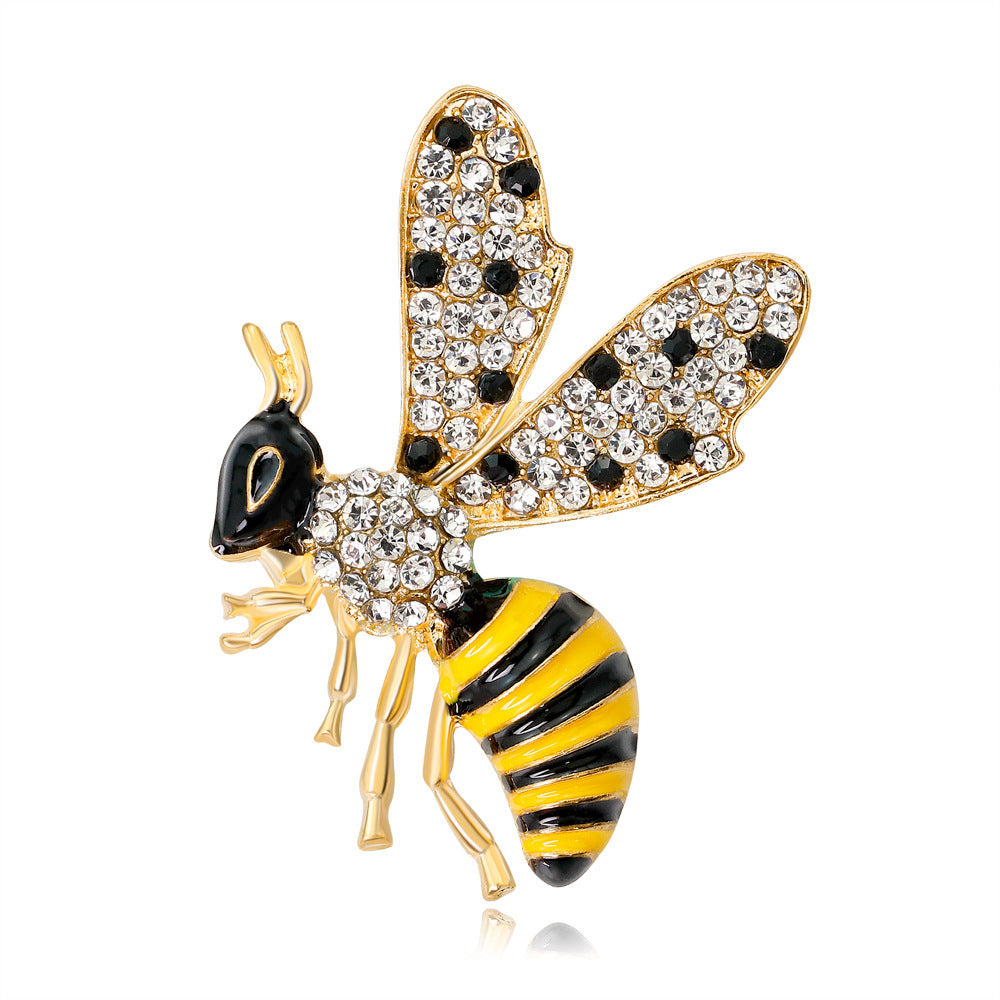 Decorative bee pin with gold, black, and yellow colors on a white background