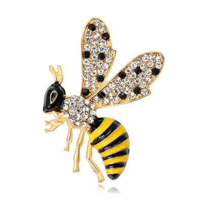 Decorative bee pin with gold, black, and yellow colors on a white background