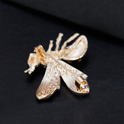 Back side of insect-shaped brooch on a black background
