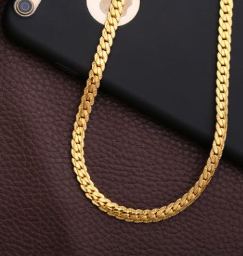 Gold chain on a dark brown textured surface