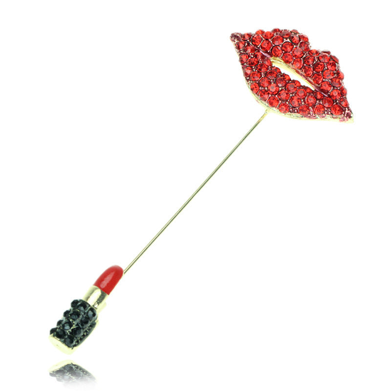 Lipstick and lip-shaped brooch with red gemstones on a white background
