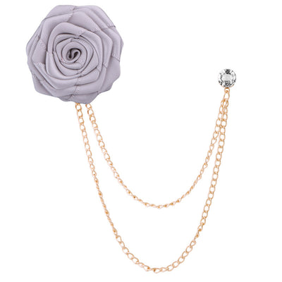 Gray rose-shaped brooch with gold chain on a white background