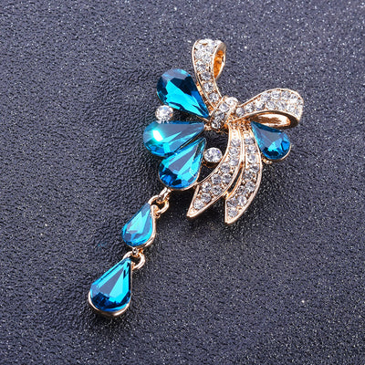 Jewelry pendant with blue gemstones and gold accents on a dark background