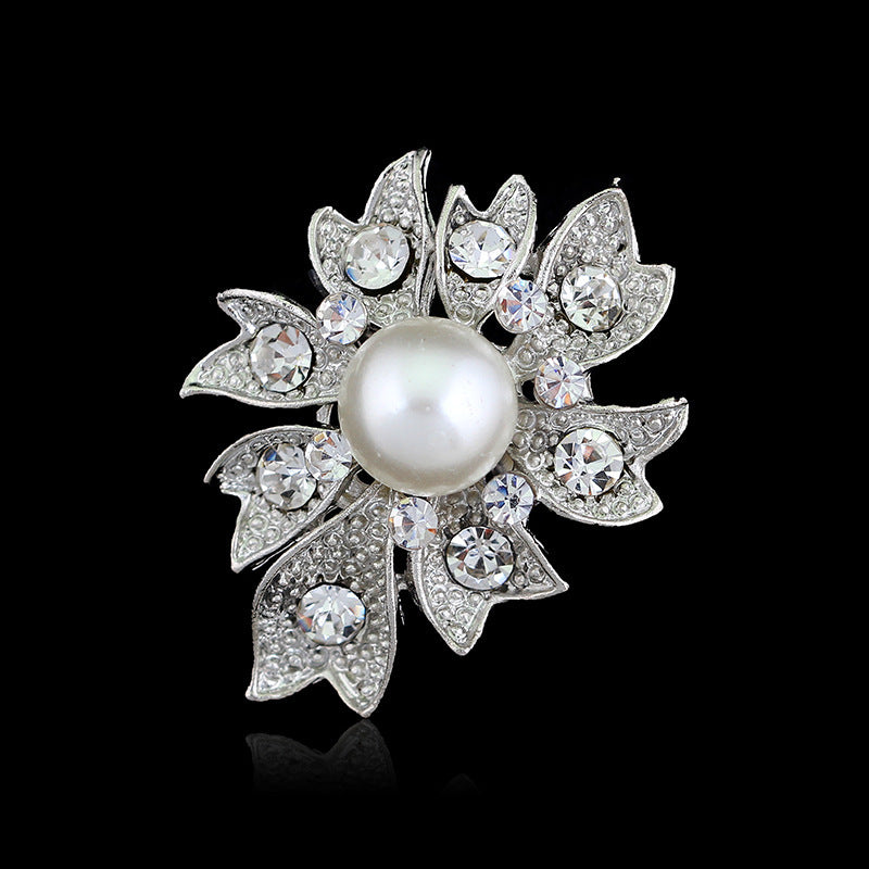 Decorative brooch with pearl and crystals on a black background