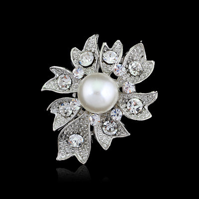 Decorative brooch with pearl and crystals on a black background