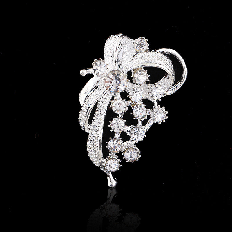 Silver brooch with crystal details on a black background