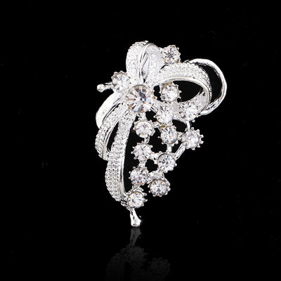 Silver brooch with crystal details on a black background