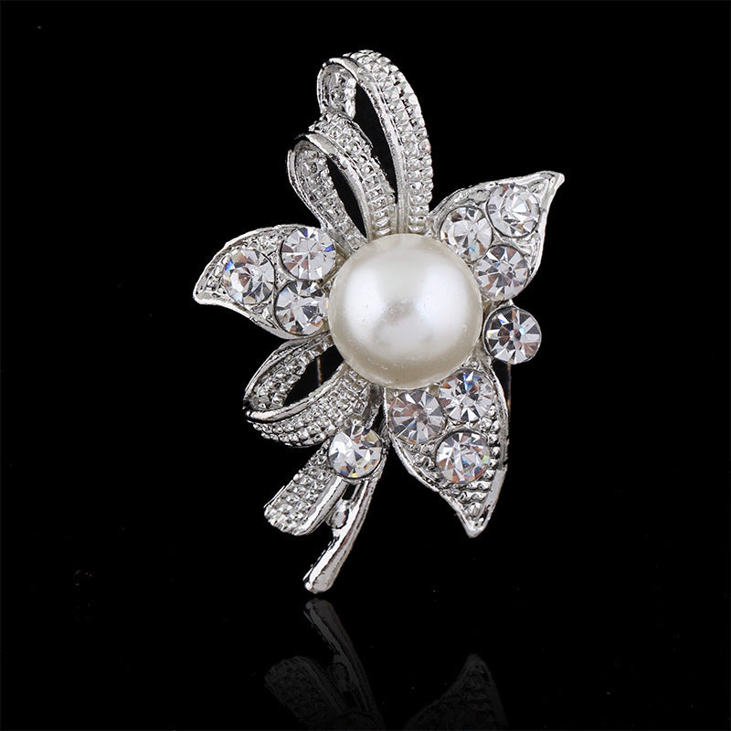 Decorative brooch with pearl and crystals on a black background