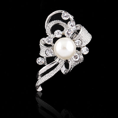 Silver brooch with a pearl and crystals on a black background
