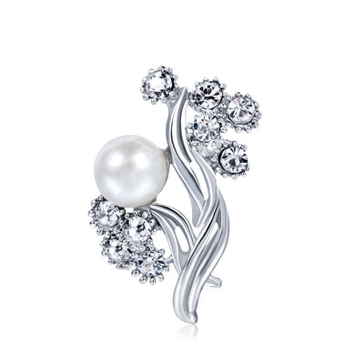 Silver brooch with a pearl and crystal embellishments on a white background