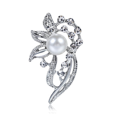Silver brooch with a pearl and crystal accents on a white background