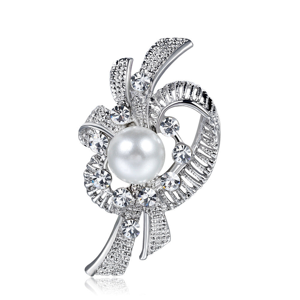 Elegant brooch with pearl and crystals on a white background