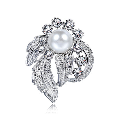 Elegant brooch with pearl and crystals on a white background