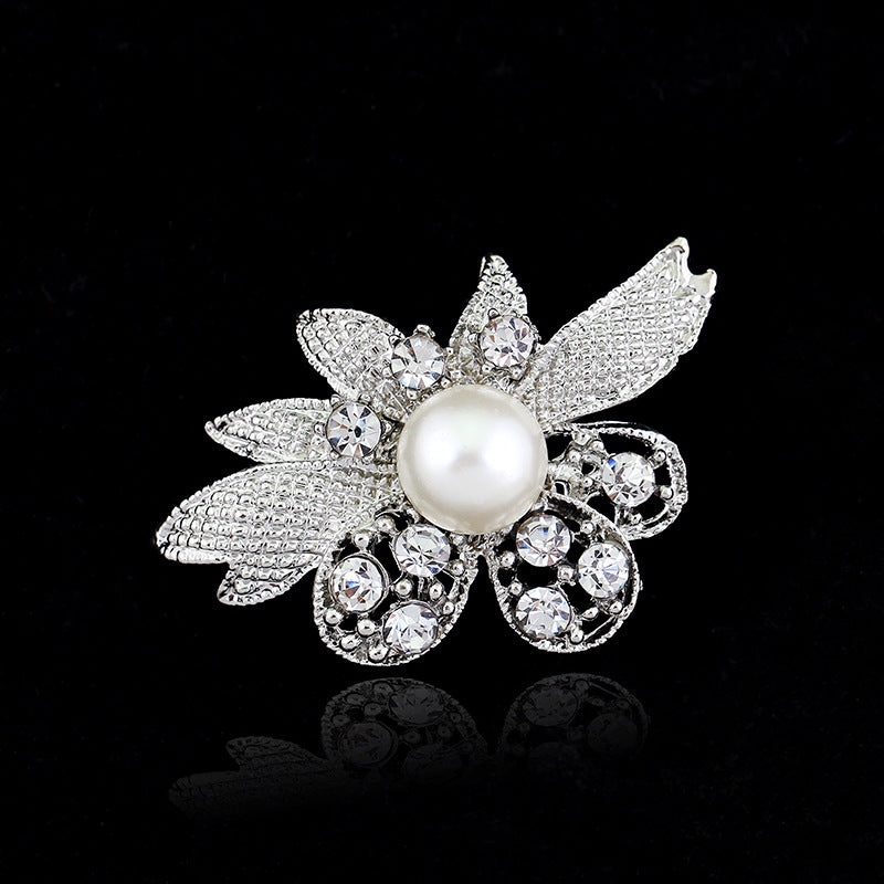 Decorative brooch with pearl and crystals on a black background