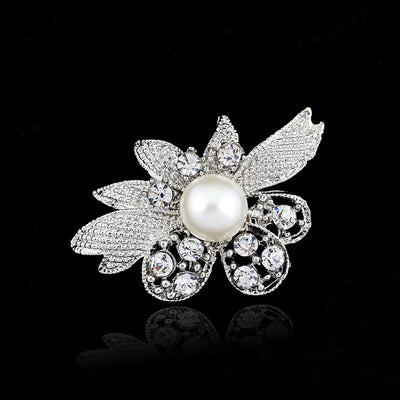 Decorative brooch with pearl and crystals on a black background