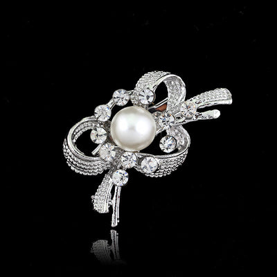 Silver brooch with a pearl and crystals on a black background