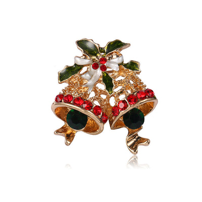 Gold bell brooch with red gemstones and green leaves on a white background