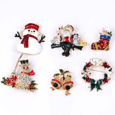 Set of Christmas-themed brooches including a snowman, Santa Claus, stocking, and wreaths on a white background.