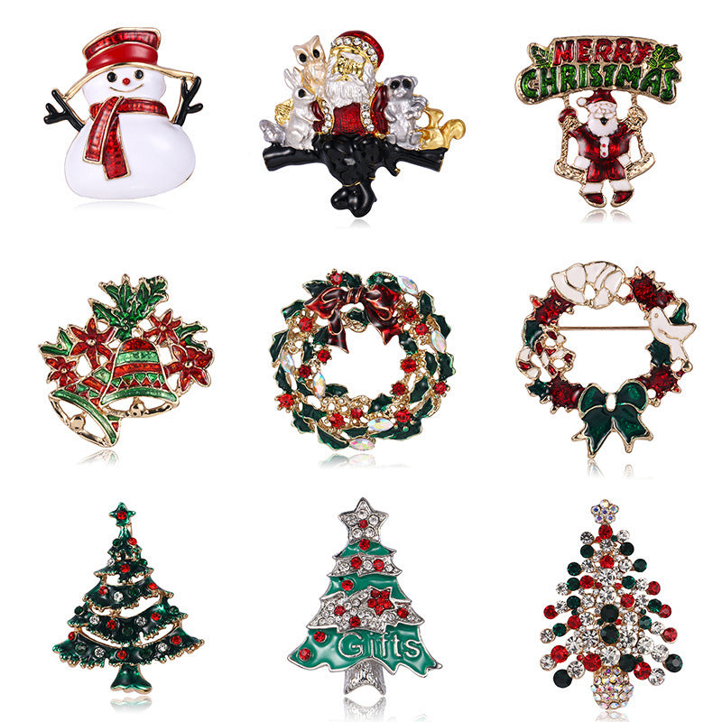Collection of Christmas-themed brooches including Santa Claus, wreaths, and trees on a white background.