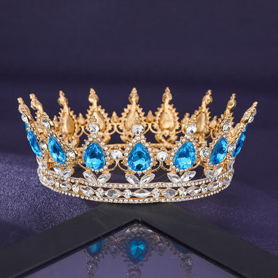 Gold crown with blue gemstones on a dark background