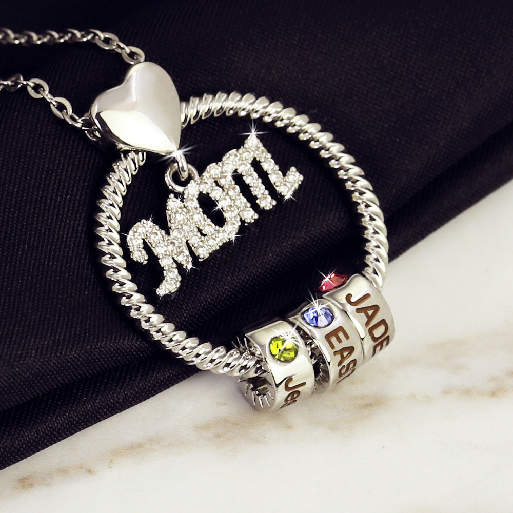 Silver necklace with heart pendant and colorful charm beads on a dark fabric background