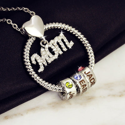 Silver necklace with heart pendant and colorful charm beads on a dark fabric background