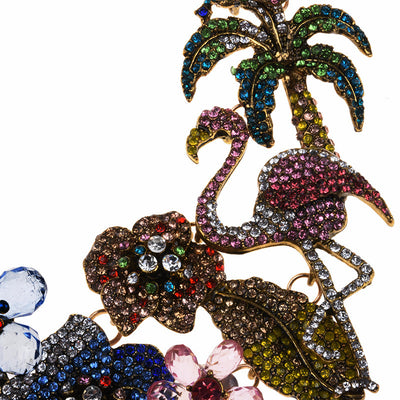 Close up of par of the necklace with flamingo, palm tree, and floral design on a white background