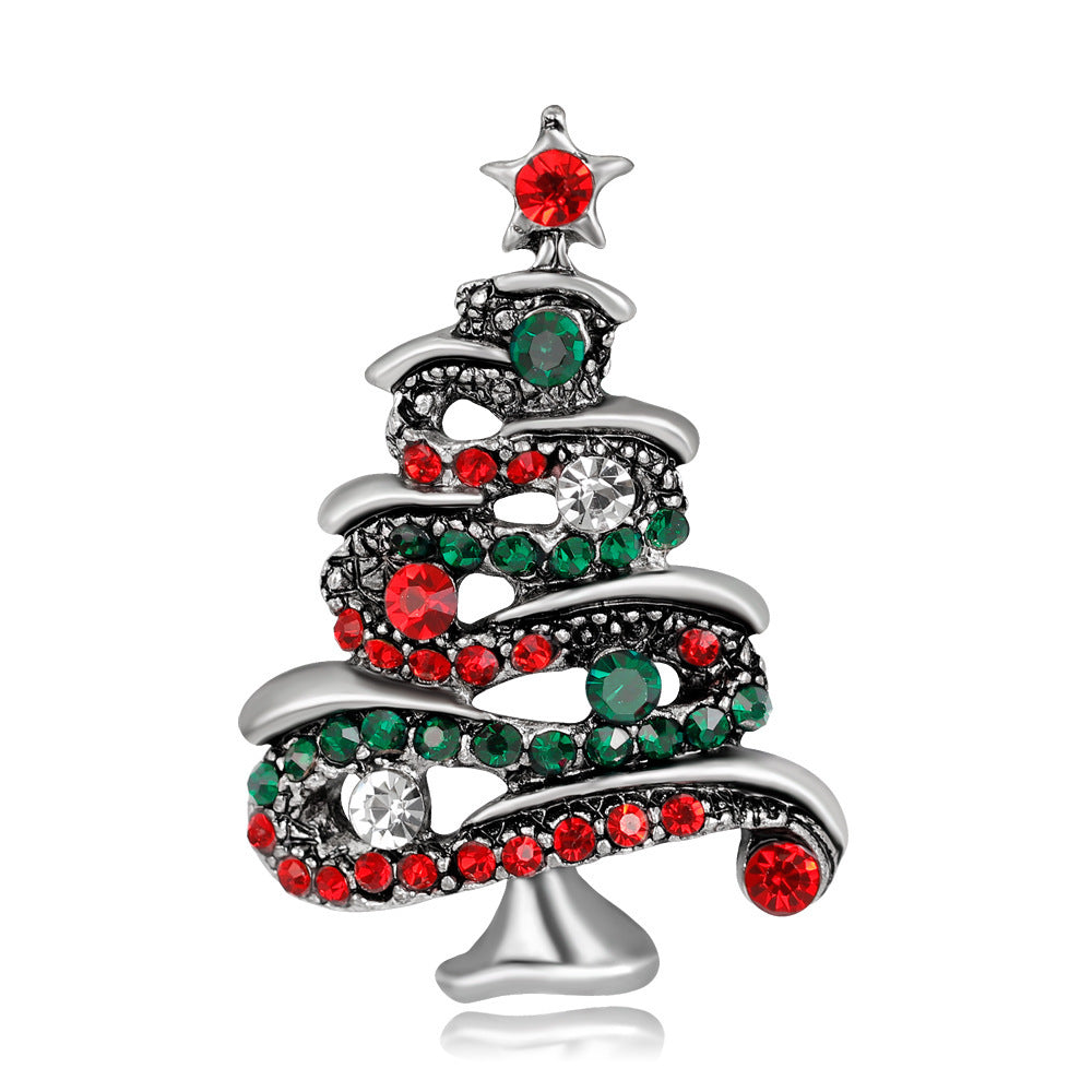 Christmas tree-shaped brooch with red and green gemstones on a white background