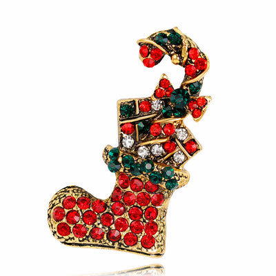 Christmas stocking brooch with red, green, and gold rhinestones on a white background