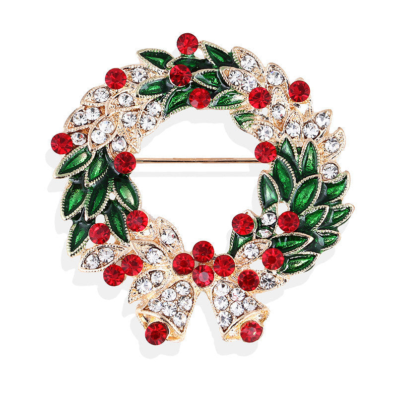Christmas wreath brooch with red berries and green leaves on a white background