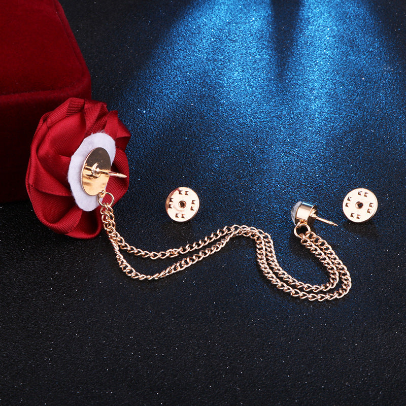 red flower and Gold chain brooch on a dark blue fabric background with a 