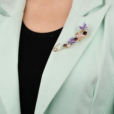 Person wearing a decorative brooch on a light green blazer