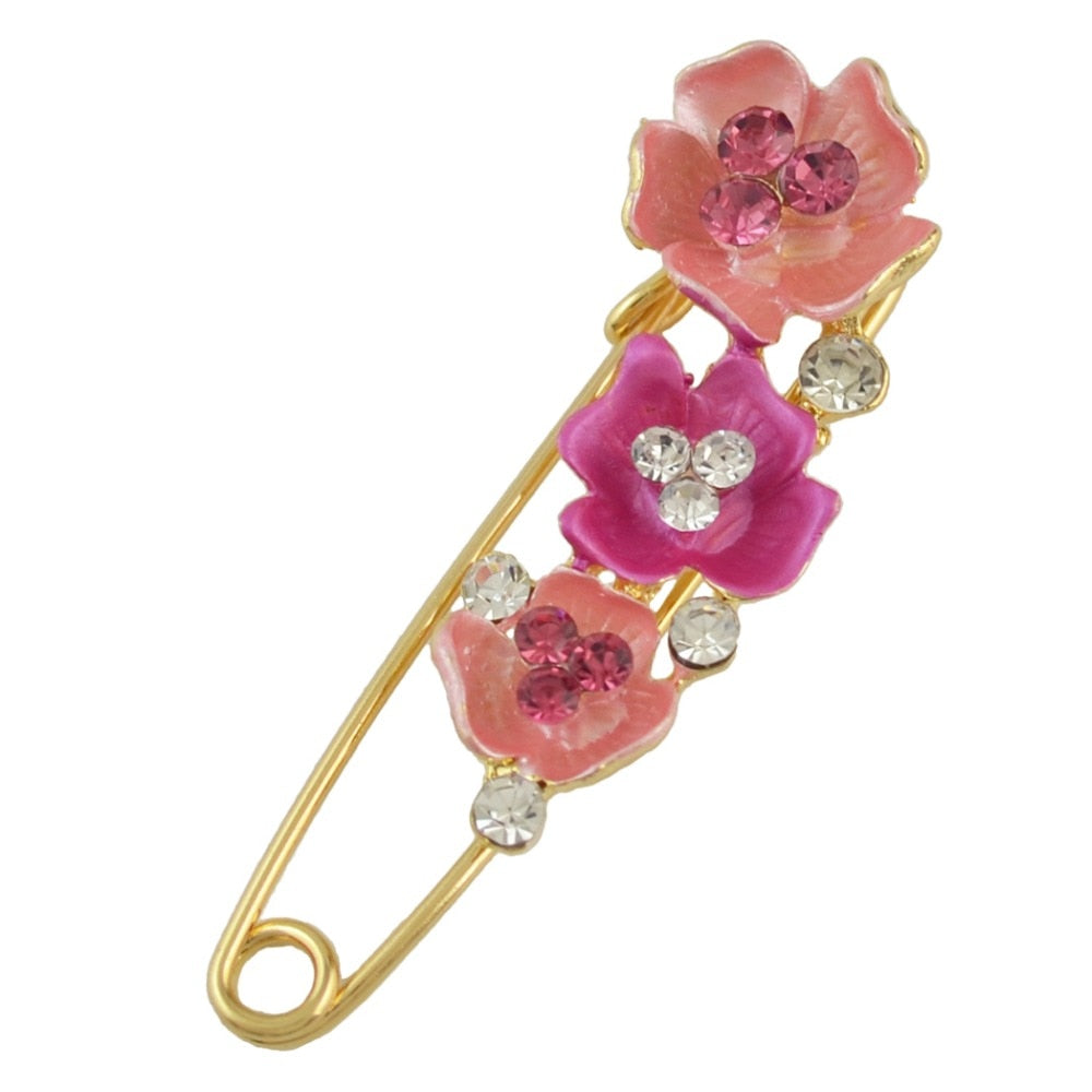 Decorative brooch with pink flowers and crystals on a white background