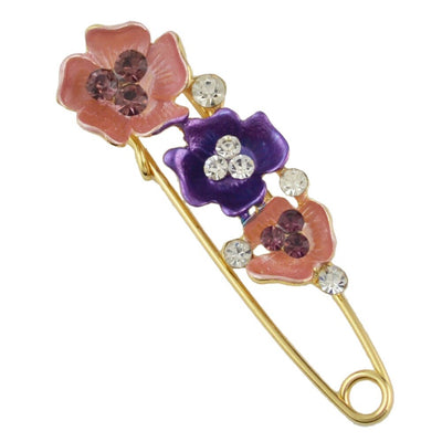Decorative brooch with floral designs and crystals on a white background