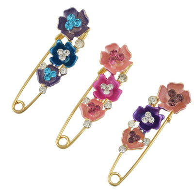 Colorful floral safety pins with gemstones on a white background